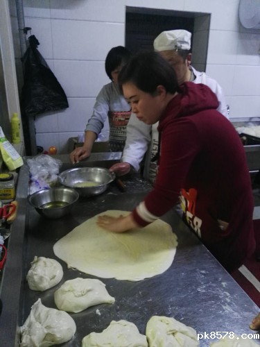 图为学员在实践制作斤饼